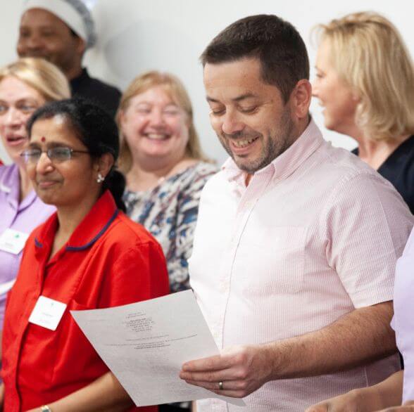 A standing man reading a paper in Southampton Care Home