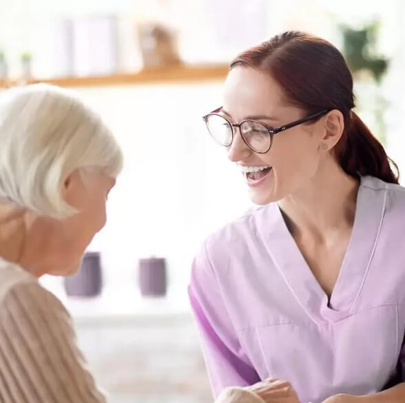 Caretaker smiling with elderly women at Southborough Care Home