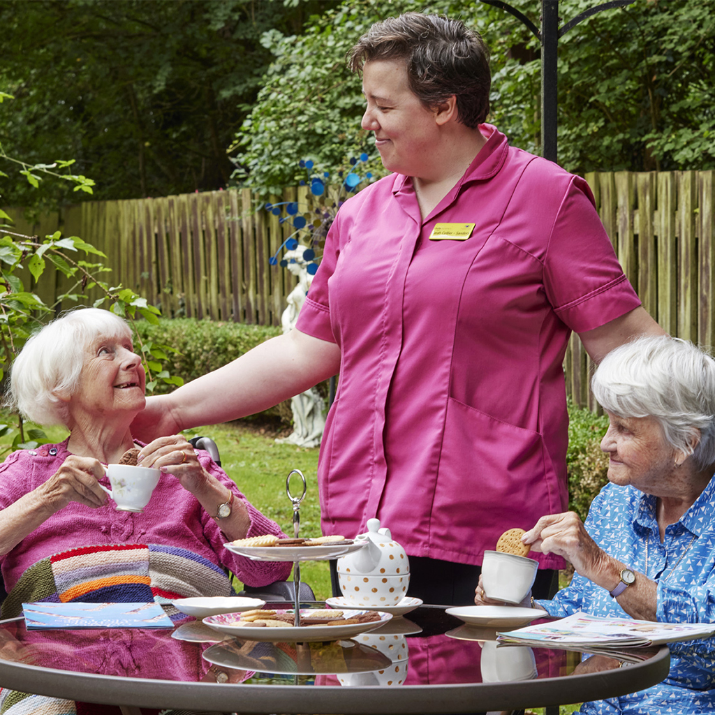 A care taker is dealing with two women patients in a care centre